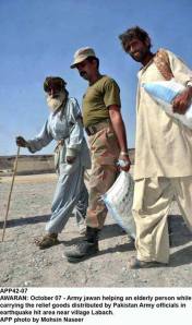 Army jawan helping an elderly person while carrying the relief goods distributed by Pakistan Army in earthquake